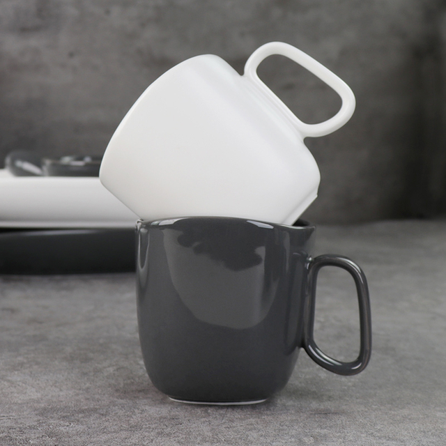 釉薬をかけられた磁器のマグカップの下にある黒と白のセラミックマグカップ