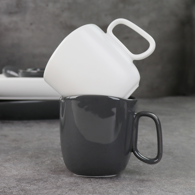 釉薬をかけられた磁器のマグカップの下にある黒と白のセラミックマグカップ