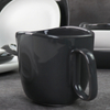 釉薬をかけられた磁器のマグカップの下にある黒と白のセラミックマグカップ