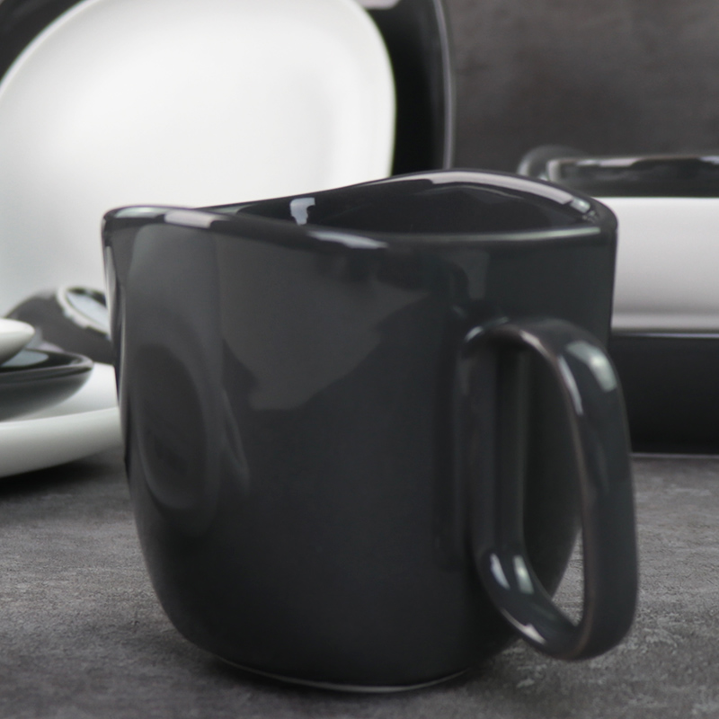 釉薬をかけられた磁器のマグカップの下にある黒と白のセラミックマグカップ